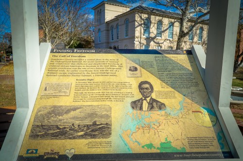 Informational sign about the history of freedom seekers, featuring a map and portrait of a historical figure.