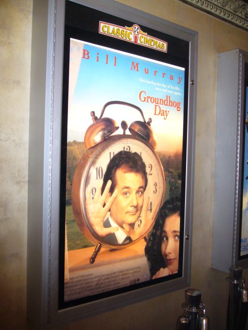 Movie poster for "Groundhog Day" featuring Bill Murray and a large clock, promoting the film's release.