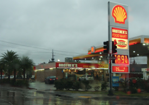 A Shell gas station and convenience store named Brother's Food Mart on a rainy day, with a price sign visible.