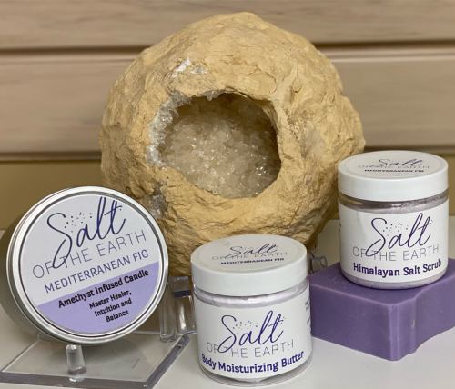 A natural salt holder with Himalayan salt, a candle, body butter, and salt scrub from "Salt of the Earth" products.