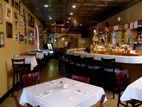 Cozy restaurant interior with tables, a bar, and walls adorned with framed photos and memorabilia.