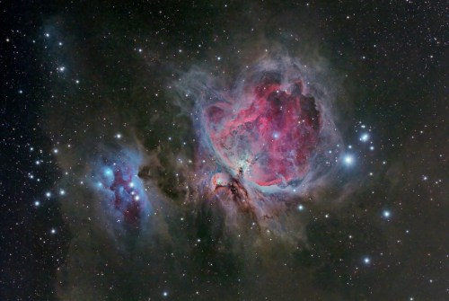 A vibrant nebula filled with swirling colors of pink, blue, and white stars against a dark cosmic background.