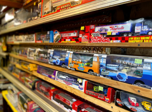 A display of various collectible toy cars and trucks in colorful packaging on shelves.