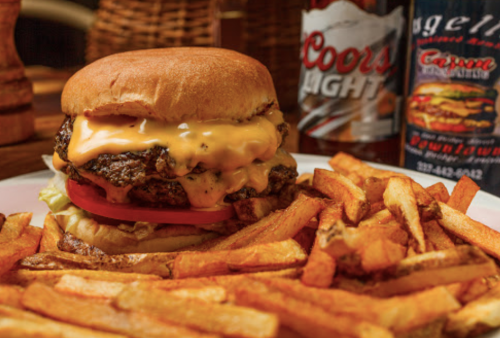 A juicy cheeseburger with melted cheese and tomato, served with crispy fries and a bottle of Coors Light.