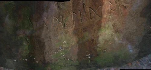Ancient rock art featuring carved symbols and markings on a textured stone surface.