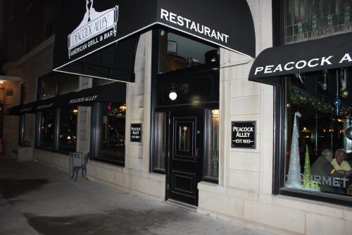 Exterior of Peacock Alley restaurant, featuring a black awning and a welcoming entrance with festive decorations.