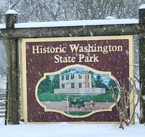 Sign for Historic Washington State Park, featuring a snowy landscape and an illustration of a historic building and carriage.