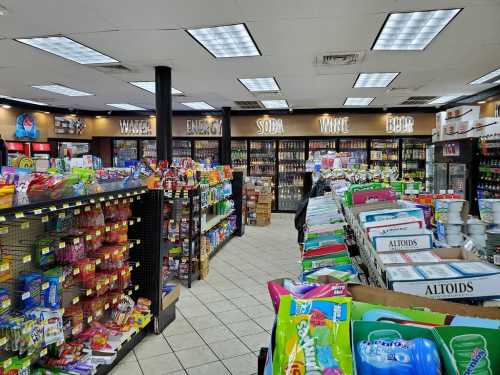 A convenience store aisle filled with snacks, drinks, and various products on shelves and displays.