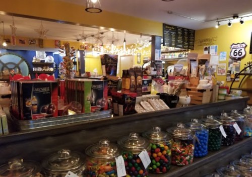 A colorful shop interior featuring jars of candy, shelves of gourmet products, and a cozy, inviting atmosphere.