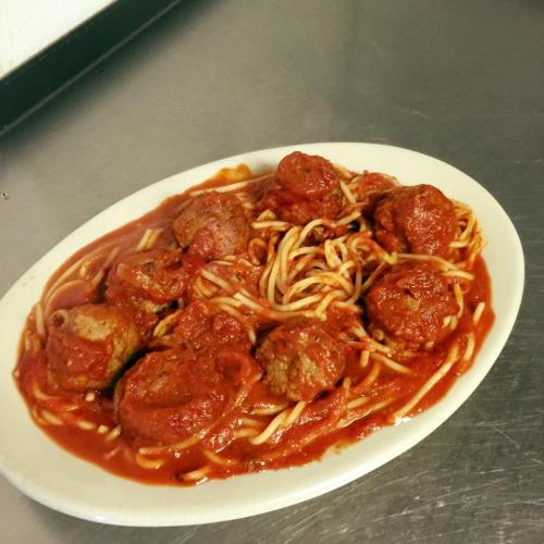 A plate of spaghetti topped with meatballs and marinara sauce, served on a white dish.