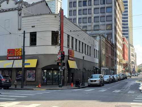 Street view of Brother's store with yellow awnings, parked cars, and tall buildings in the background.