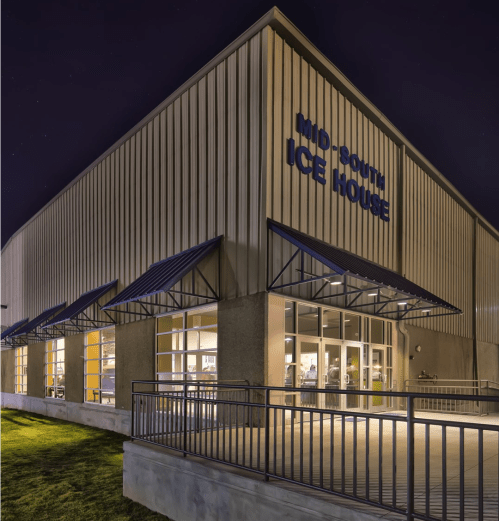 Exterior of the Mid-South Ice House at night, featuring a modern design and illuminated signage.