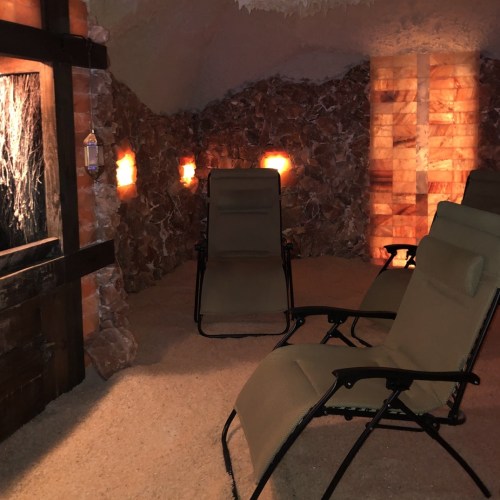 A cozy room with stone walls, salt lamps, and reclining chairs for relaxation.