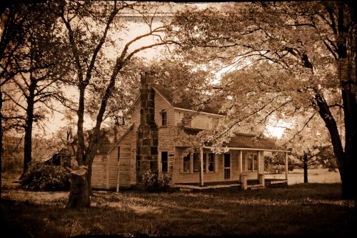 A vintage-style image of a rustic house surrounded by trees, with a stone chimney and a serene, nostalgic atmosphere.
