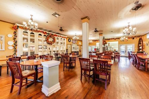 Cozy restaurant interior with wooden tables, chairs, and autumn decorations on the walls and ceiling.