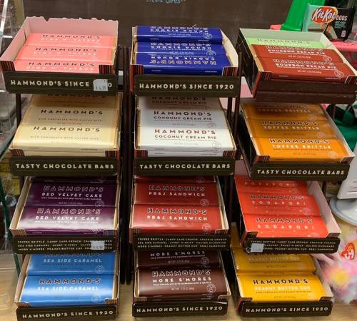 A display of colorful Hammond's chocolate bars in various flavors, neatly arranged in boxes on a shelf.