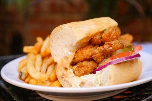 A crispy chicken sandwich with lettuce, tomato, and pickles, served with a side of golden French fries.