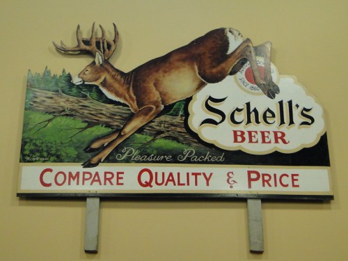 Vintage sign for Schell's Beer featuring a leaping deer, with the text "Compare Quality & Price."
