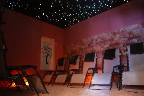 A serene relaxation room with reclining chairs, a starry ceiling, and warm lighting, creating a calming atmosphere.