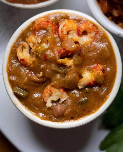 A bowl of flavorful crawfish stew with vegetables, rich brown sauce, and tender crawfish pieces.