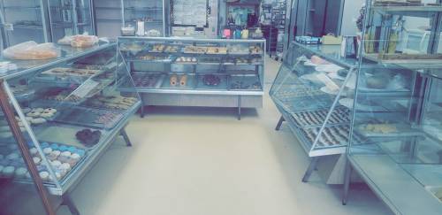 A bakery display with glass cases filled with various pastries and desserts, showcasing colorful treats and baked goods.