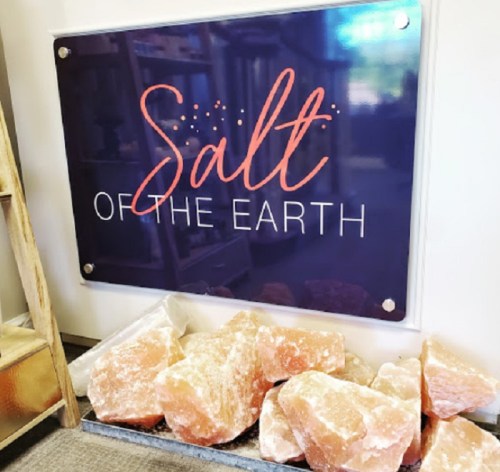 A sign reading "Salt of the Earth" above a display of large salt rocks.