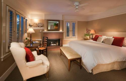 Cozy bedroom with a large bed, fireplace, armchair, and warm lighting, creating a welcoming atmosphere.