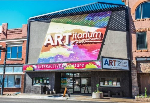 Colorful building facade featuring "ARTitorium on Broadway" sign, promoting an interactive art adventure.