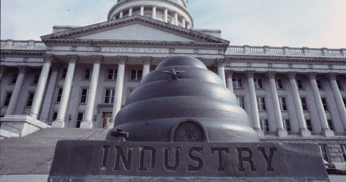 A large beehive sculpture labeled "INDUSTRY" in front of the Utah State Capitol building.