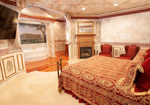 Luxurious bedroom with ornate decor, a fireplace, and a mural of ancient architecture. Rich red and gold accents throughout.