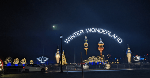 A festive archway reading "WINTER WONDERLAND" illuminated with colorful lights, surrounded by holiday decorations.