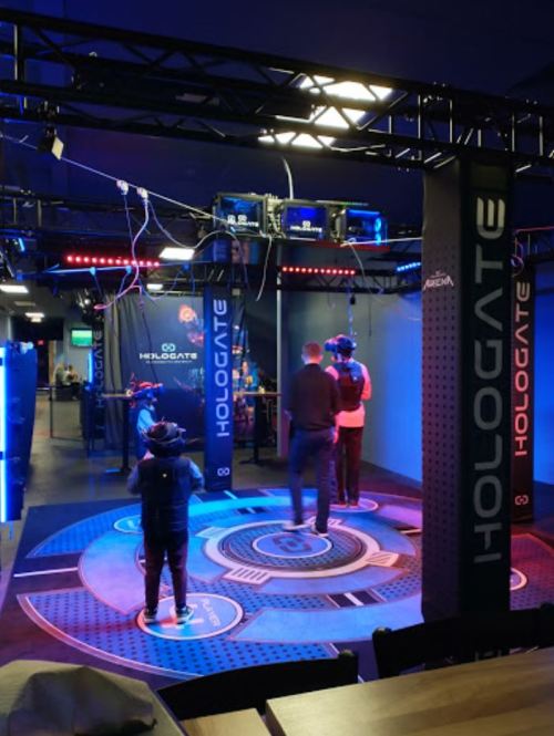 A virtual reality gaming setup with players wearing headsets in a high-tech environment.