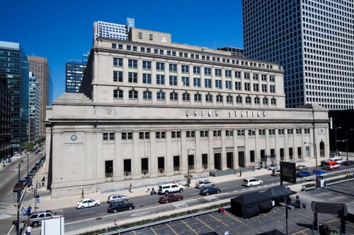Historic United States Station building with a classic facade, surrounded by modern skyscrapers and busy streets.