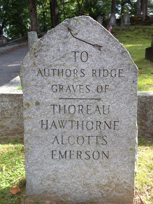 Gravestone marking the Authors Ridge, honoring Thoreau, Hawthorne, Alcott, and Emerson in a serene cemetery setting.
