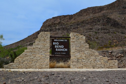 Sign welcoming visitors to Big Bend Ranch State Park, framed by stone structures and surrounded by rocky terrain.