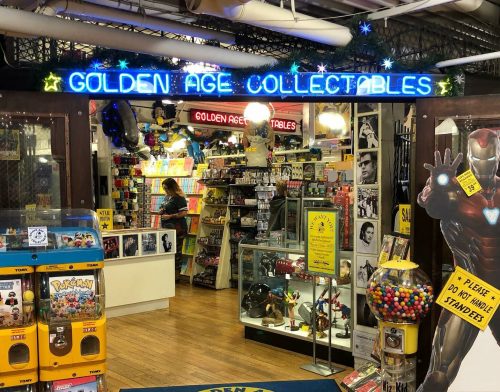 Entrance to a colorful collectibles store with neon signs, gumball machines, and various merchandise displays.