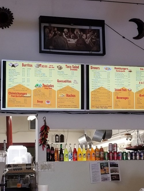 Menu board displaying various Mexican food items like burritos, tacos, and nachos, with colorful drinks below.