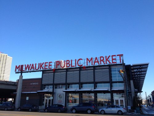 Milwaukee Public Market building with a clear blue sky above and bright red signage.