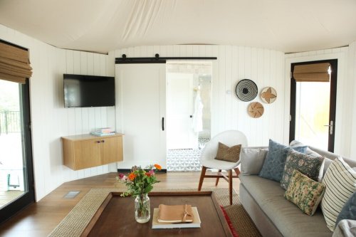 Cozy interior of a modern living space with a sofa, coffee table, TV, and decorative elements. Bright and inviting atmosphere.