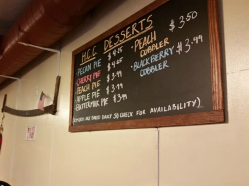 Chalkboard menu listing H.C.C. desserts with prices: pecan pie, cherry pie, peach pie, apple pie, butter milk pie, and cobblers.