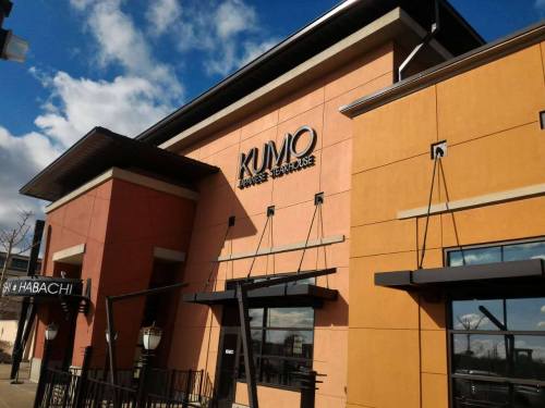 Exterior of Kumo Japanese Steakhouse, featuring a modern design with large windows and a clear blue sky.