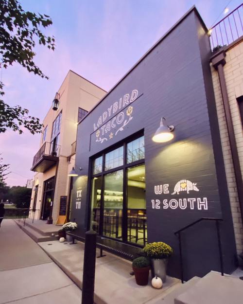 Exterior of Ladybird Taco in the 12 South neighborhood, featuring a colorful mural and welcoming entrance at dusk.