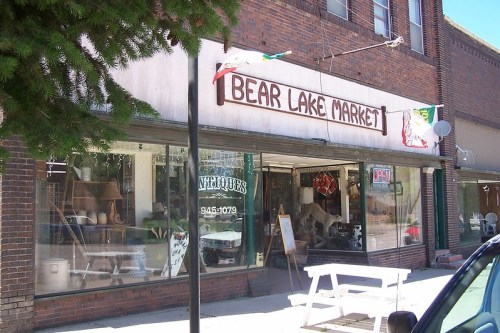 Exterior of Bear Lake Market, featuring a vintage storefront with a sign and various items displayed in the windows.