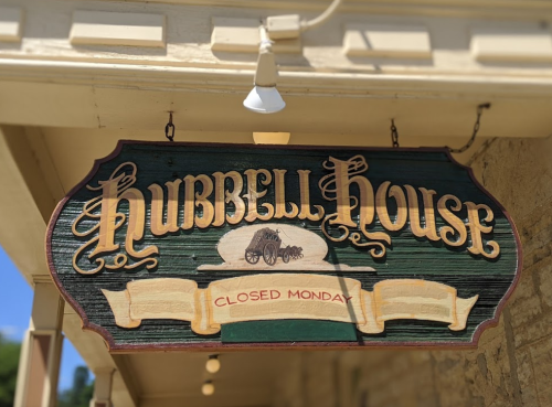 Sign for Hubbell House, featuring decorative lettering and stating "Closed Monday."