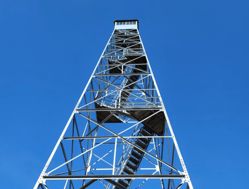 A tall metal tower with a staircase, set against a clear blue sky.