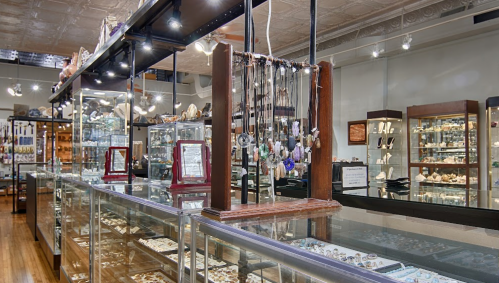 A jewelry store interior featuring display cases filled with various necklaces, rings, and decorative items.