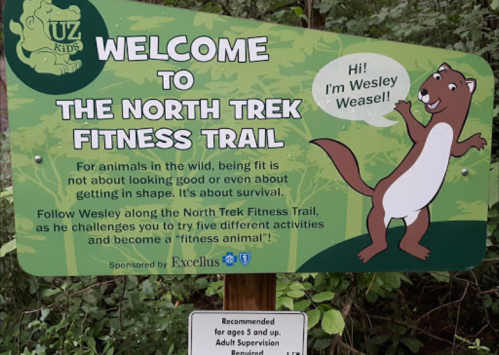 Sign welcoming visitors to the North Trek Fitness Trail, featuring Wesley Weasel and promoting fitness activities for kids.