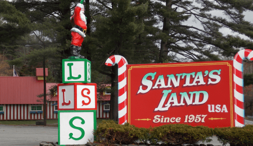 Colorful sign for Santa's Land USA, featuring a Santa figure and candy cane decorations, established in 1957.