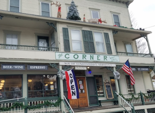 A festive building in South Londonderry, Vermont, decorated for the holidays with wreaths and a sign that says "OPEN."