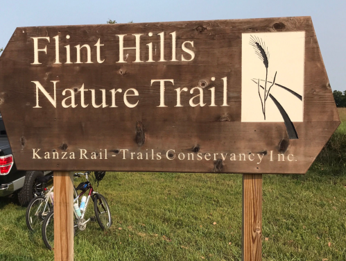Sign for Flint Hills Nature Trail, featuring a logo and information about Kanza Rail-Trails Conservancy Inc.